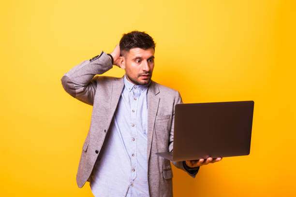 istock Portrait man forget or problems confused with laptop isolated on yellow background. 1210552870
