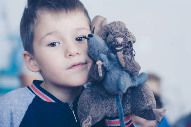 istock Boy's face with a toy mouse, close-up 1210553035