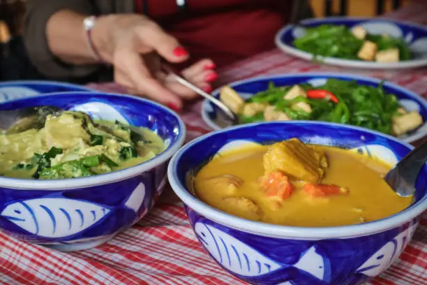 Eating Asian food with garlic spinach and pumpkin curry in the Cambodian city Siem Reap