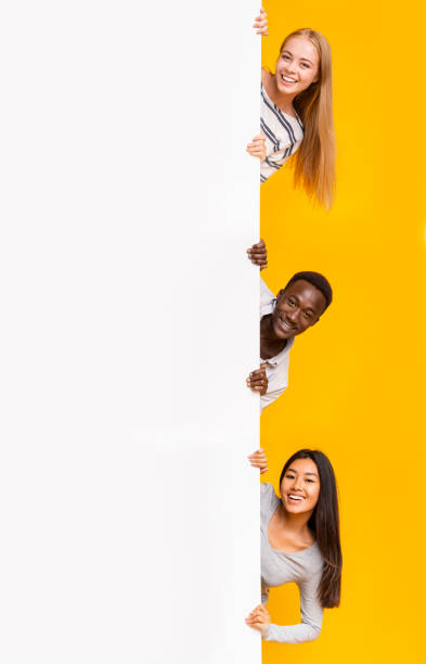 istock Cheerful friends looking from big blank board for advertising 1210555431