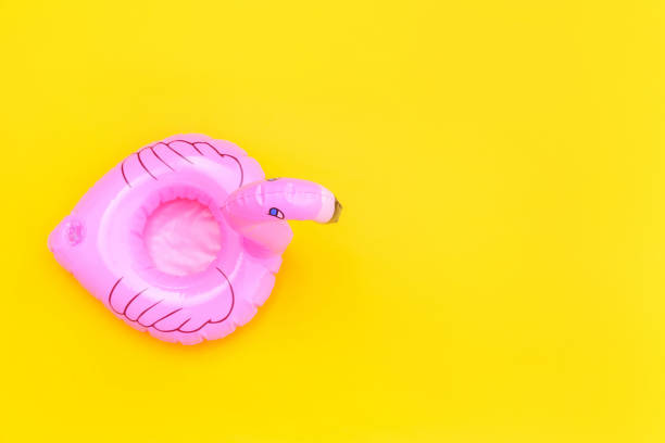 Summer beach composition. Simply minimal design with pink Inflatable flamingo isolated on yellow background. Pool float party, trendy celebrity fashion concept. Flat lay top view copy space composición de playa de verano. diseño simplemente minimalista con flamenco inflable rosa aislado sobre fondo amarillo. fiesta de flotador en la piscina, concepto de moda de la celebridad de moda. espacio de copia de vista superior de la vista superior p
