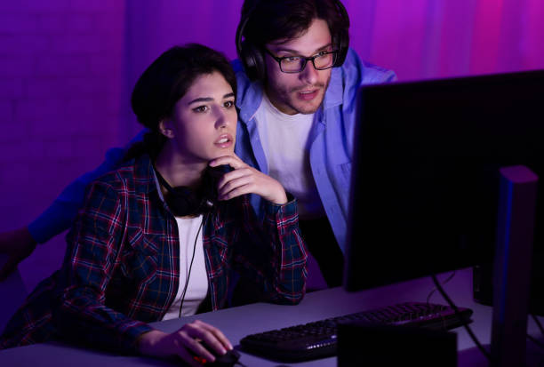 istock Millennial Couple Playing Computer Games Sitting Together At Home 1210556547