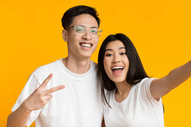 istock Beautiful asian couple smiling and taking selfie 1210556766