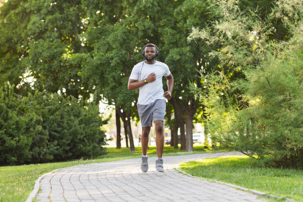 istock Sporty african guy is jogging in the park 1210556783