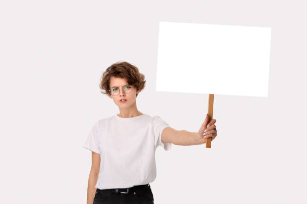 istock Concerned female protester holding empty signboard with copy space. 1210558574