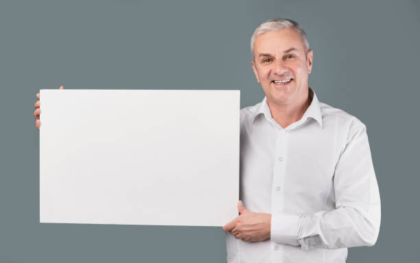 istock Portrait of elderly man holding blank white placard 1210559440