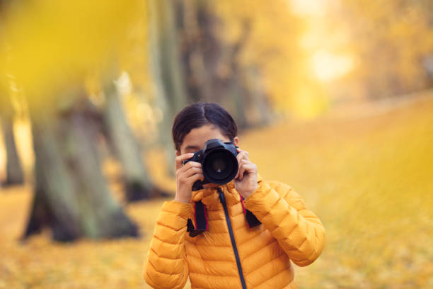 istock Girl taking a picture with a DSLR camera 1210561821