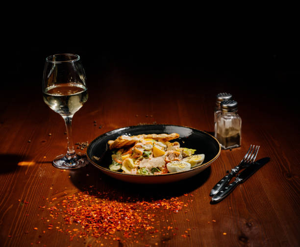 istock Caesar salad on black plate on wooden table 1210562371