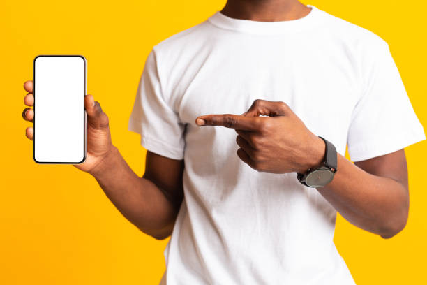 istock Unrecognizable african guy holding latest phone on yellow 1210562796