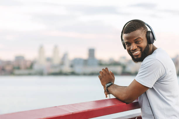 istock Handsome cheerful african guy resting after exercising on the bridge 1210562848