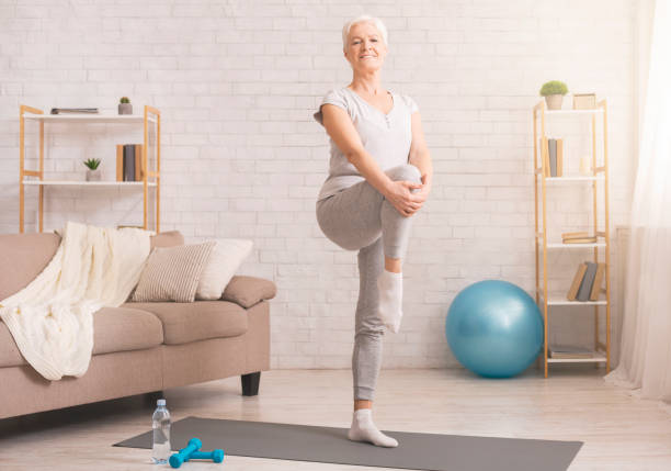 istock Active senior woman warming up at home 1210562927