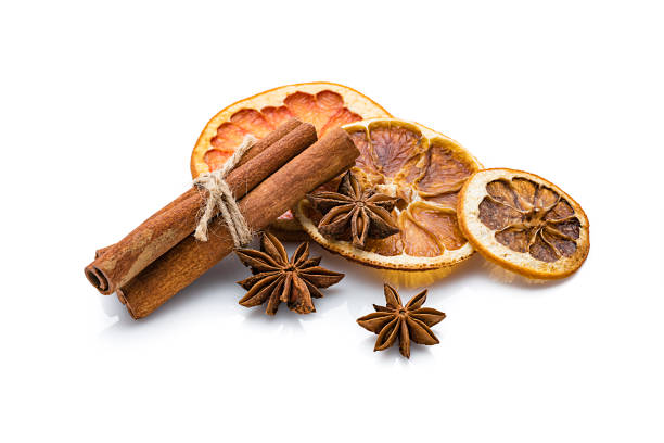 Aromatherapy: dried orange slices, cinnamon sticks and star anise isolated on white background. Predominant colors are orange, brown and white. High resolution 42Mp studio digital capture taken with Sony A7rII and Sony FE 90mm f2.8 macro G OSS lens