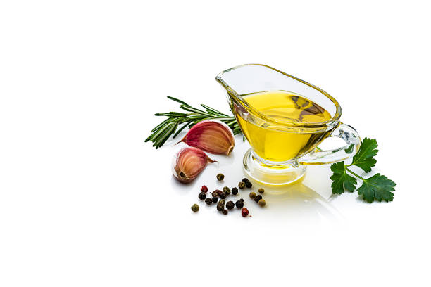 cottura e condimento: olio d'oliva in una barca di sugo di vetro, prezzemolo, rosmarino, aglio e pepe su sfondo bianco - light vegetarian food garlic spice foto e immagini stock
