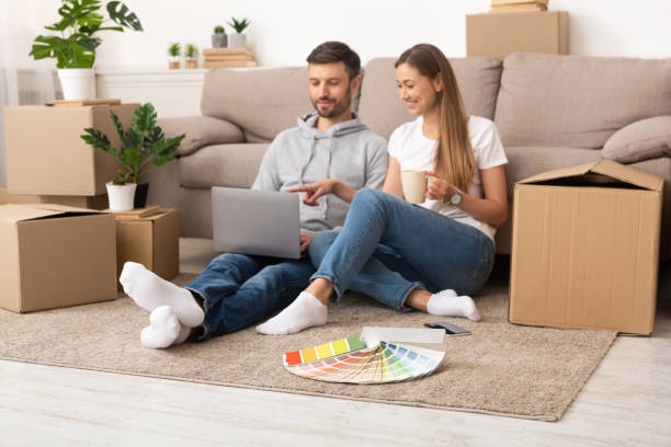 istock Young couple sitting in new apartment with unpacked boxes 1210564766