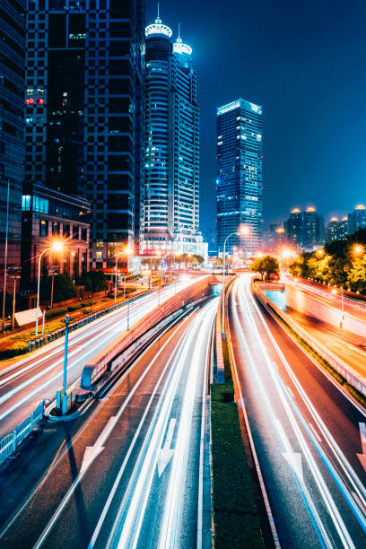 istock the light trails on the modern building background in shanghai china. 1210565308