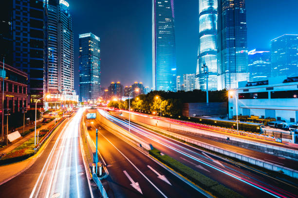 istock the light trails on the modern building background in shanghai china. 1210565317