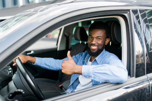 istock happy african man giving thumb up inside car 1210565356