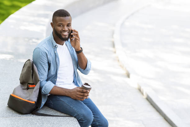 istock Handsome black man talking on cellphone outdoors and drinking takeaway coffee 1210565738