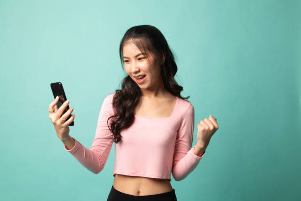 istock Successful young Asian woman with mobile phone. 1210565843