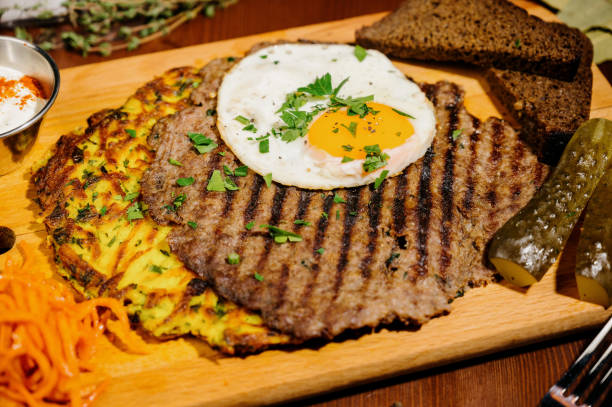 istock fried eggs with meat on a wooden board 1210566297