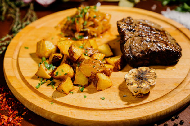 istock fried potatoes with meat on a plate on a wooden table 1210566862