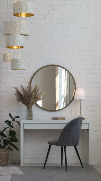 silla de terciopelo gris moderno, escritorio, espejo redondo y lámpara de mesa y accesorios para el hogar y lámpara de araña - round mirror fotografías e imágenes de stock