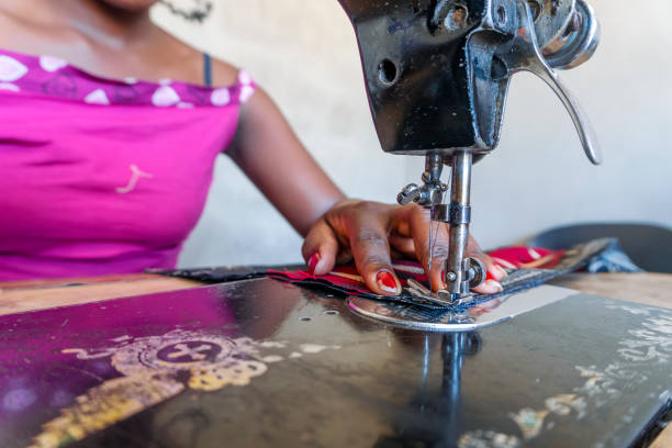 istock Seamstress using her black sewing machine to do African dresses 1210567900