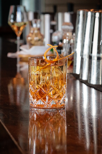 Elegant Cocktail with orange garnish on Bar Counter