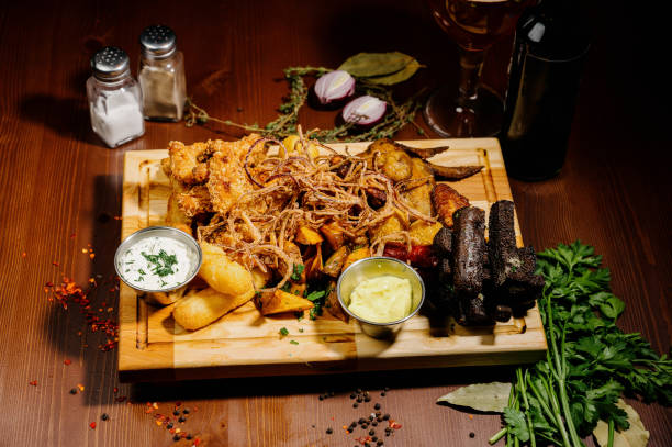 istock Selection of beer and snacks.Chips, fish, beer sausages on the table 1210568921