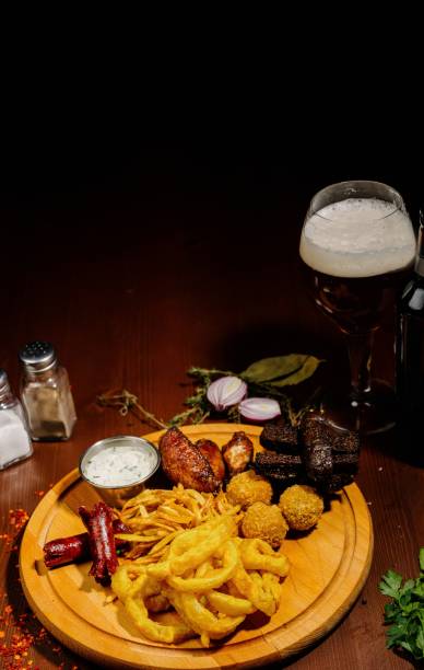 istock Selection of beer and snacks.Chips, fish, beer sausages on the table 1210568923