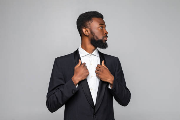 istock Successful young african businessman in suit standing over gray background 1210569006