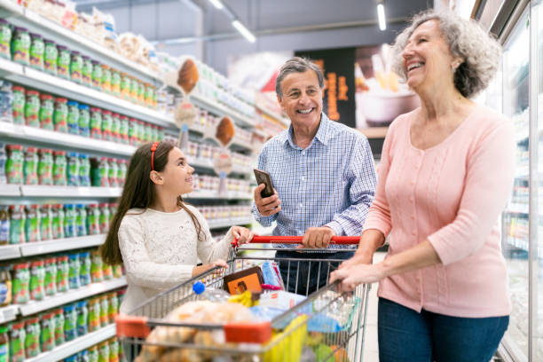 nipote che aiuta i nonni al supermercato - senior adult aging process supermarket shopping foto e immagini stock