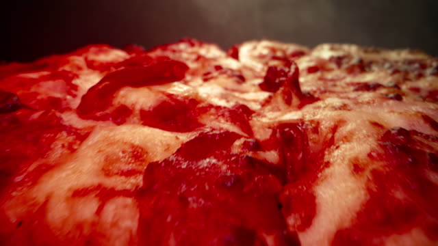 Ultra Close-Up Wide Angle Macro Shot of Delicious Steaming Hot Deep Dish Pepperoni Pizza Fresh Out Of The Oven on a Cooling Rack Under a Heat Lamp With a Dolly Camera Shot Rolling Backwards and Ending with Copy Space