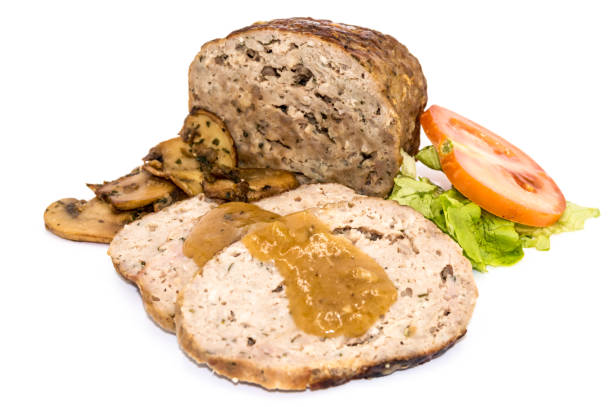 Meatloaf cut into slices with mushrooms, tomato and salad stock photo
