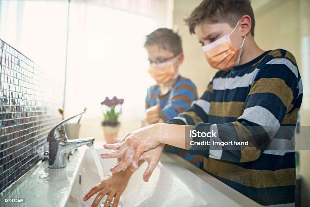Little boys wearing face masks washing hands thoroughly Little boys washing hands in bathroom very thoroughly. 
Boys are wearing face masks.
Nikon D850 Washing Hands Stock Photo