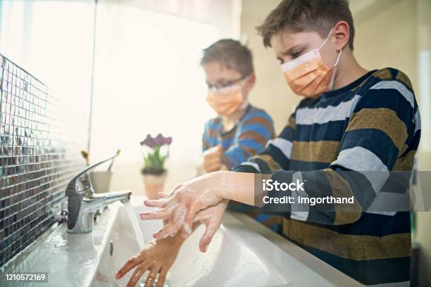 Little Boys Wearing Face Masks Washing Hands Thoroughly Stock Photo - Download Image Now