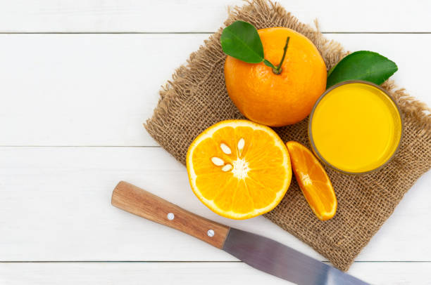 istock Orange juice and oranges on white vintage wood table. 1210572190