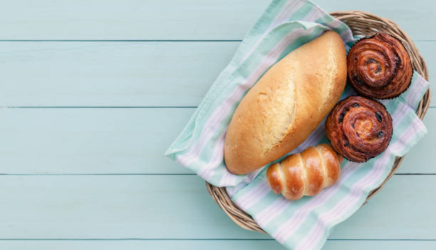 istock Baked bread and buns on light blue wooden table. 1210572529