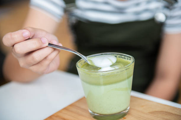 istock Hot green tea latte with spoon on wooden plate 1210574103