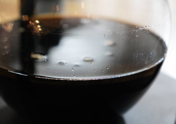 Stock photo showing close-up view of a freshly made hot cup of Americano coffee (espresso and water) in a white, china cup and saucer, isolated on a black background.
