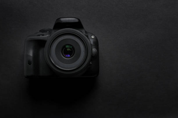 istock Still life flat lay in black tones mirrored photo camera on a monochrome background 1210580888