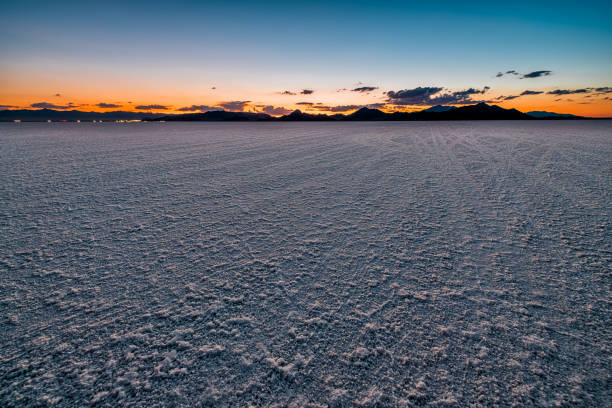 Bonneville Salt Flats landscape dark twilight sunset near Salt Lake City, Utah and silhouette view of mountains and cars on highway road Bonneville Salt Flats landscape dark twilight sunset near Salt Lake City, Utah and silhouette view of mountains and cars on highway road bonneville salt flats stock pictures, royalty-free photos & images