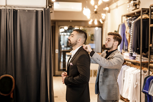 Young businessman trying on new suit for an important event.