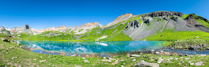 Panoramic view of turquoise Ice lake near Silverton, Colorado on summit rocky mountain peak and snow in August 2019 summer panorama