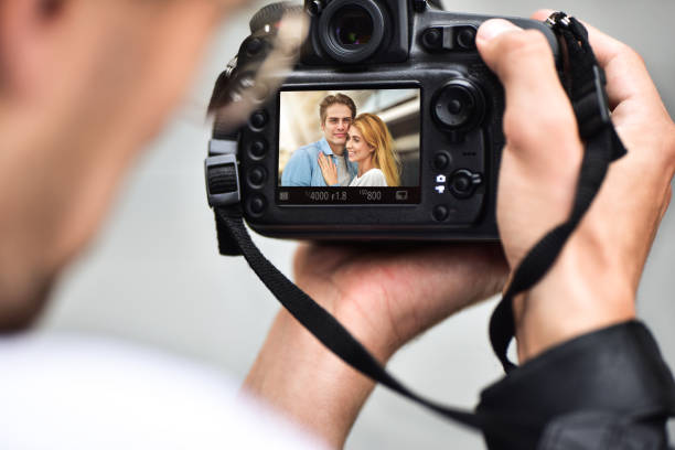 istock Close up male hands hold professional camera and make a photo. 1210582948