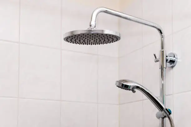 Modern tiles tiled bathroom with shower heads closeup in luxury house room and isolated clean object