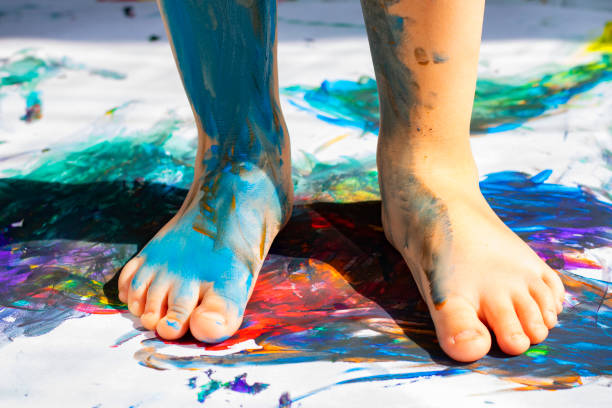 istock painted kids two legs on bright paper, playig with paints 1210584472