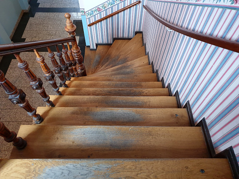 Old rustic wooden staircase in a hallway stairwell