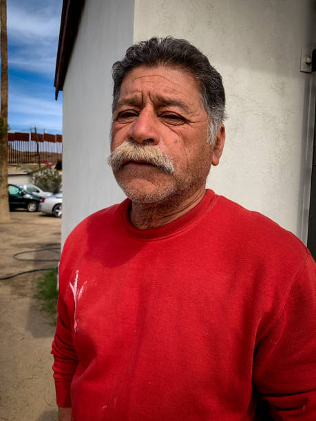 Portrait of a Senior Mexican Man with a Big Mustache in the town of Los Algodones Mexico Near Yuma Arizona with the Iconic Border Wall in the Background Portrait of a Senior Mexican Man with a Big Mustache in the town of Los Algodones Mexico Near Yuma Arizona with the Iconic Border Wall in the Background yuma photos stock pictures, royalty-free photos & images