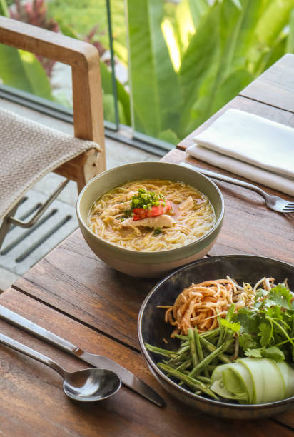 Asian Noodle Soup with fresh Herbs Asian Noodle Soup with fresh Herbs. Traditional Khmer Cambodian Prawn Coconut Soup with Parsley, Cucumber, Garlic and Cilantro khmer stock pictures, royalty-free photos & images